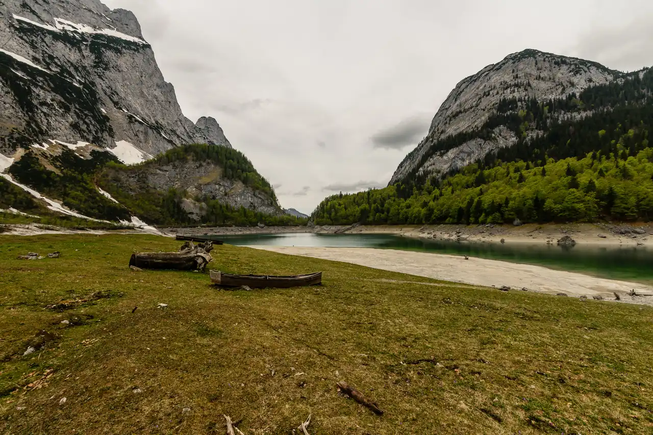 Hinterer Gosausee mit grasigem Ufer und Felswänden